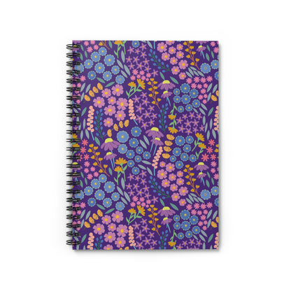 Floral Spiral Notebook with vibrant floral pattern, featuring pink, blue, and yellow blossoms on a purple background. Ideal for jotting notes or sketching, it embodies FireBrook Designs' joyful, uplifting essence.
