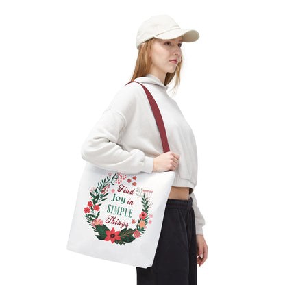 Woman in white hat holding the Find Joy in Simple Things tote bag with a floral design, highlighting its stylish and practical features.