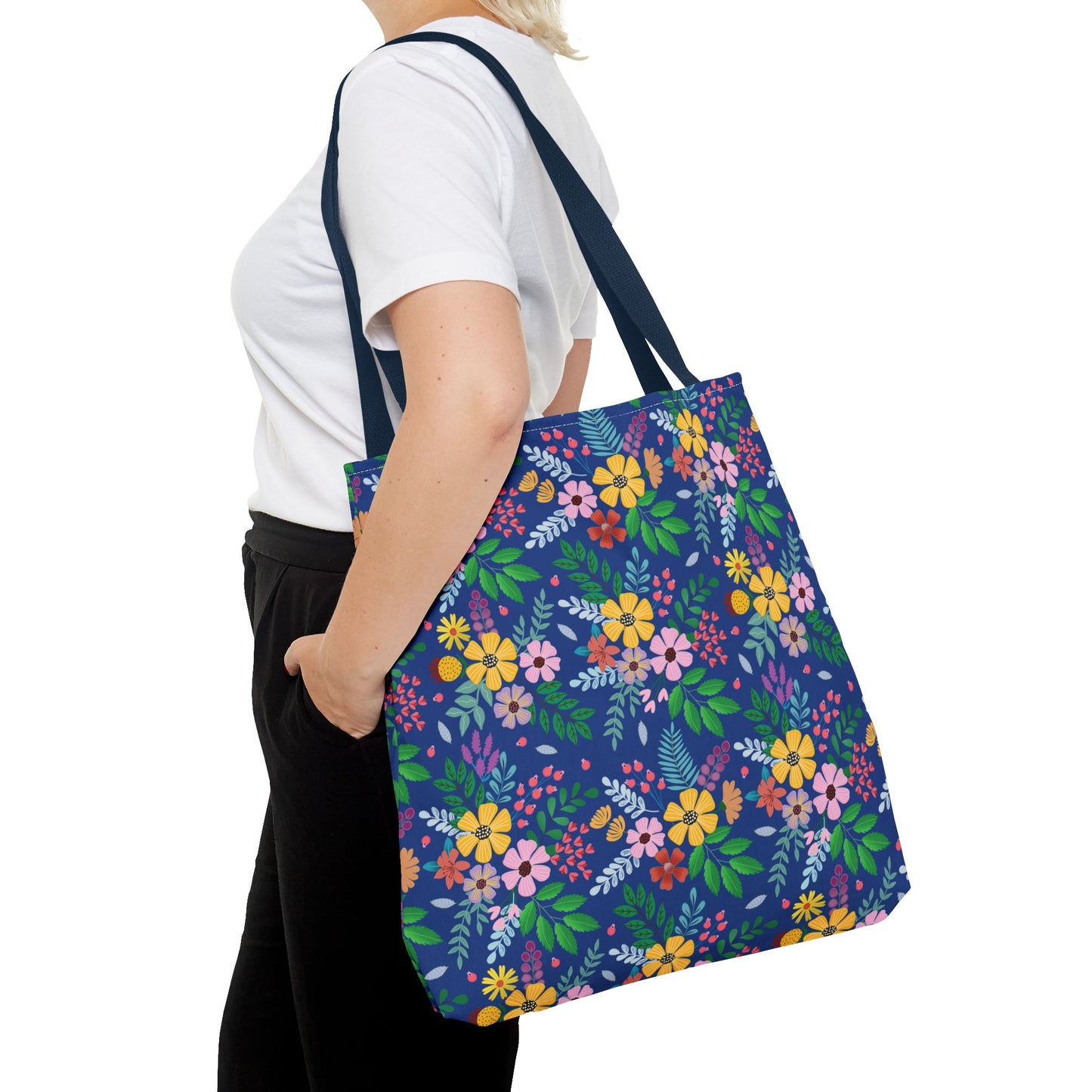 Floral Tote Bag featuring a vibrant floral pattern with navy-blue straps, carried by a person in casual attire. Ideal for summer outings, aligning with FireBrook Designs' uplifting, joyful aesthetic.