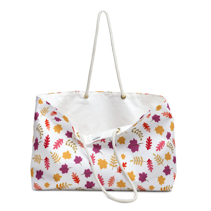 Weekender Bag with soft rope handles, featuring a vibrant autumn leaf pattern on a white backdrop. Its spacious design and luxurious interior make it ideal for stylish, joyful travel.