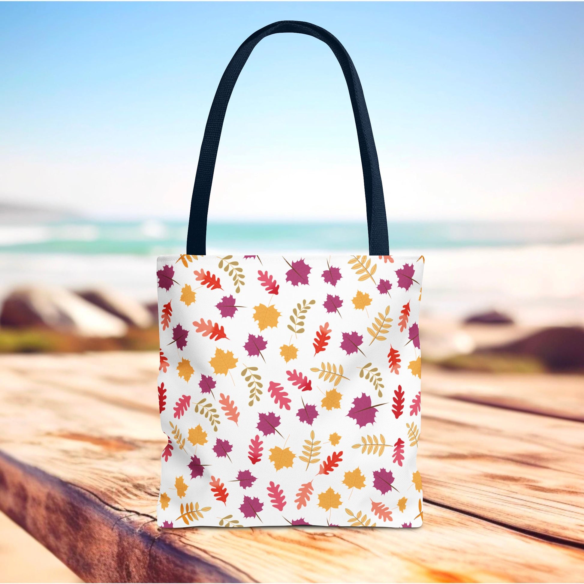 Autumn Leaves Tote Bag features a stylish scattered leaf pattern in warm shades on a white tote, with dark handles, perfect for daily use. Made from durable polyester, it enhances everyday convenience.