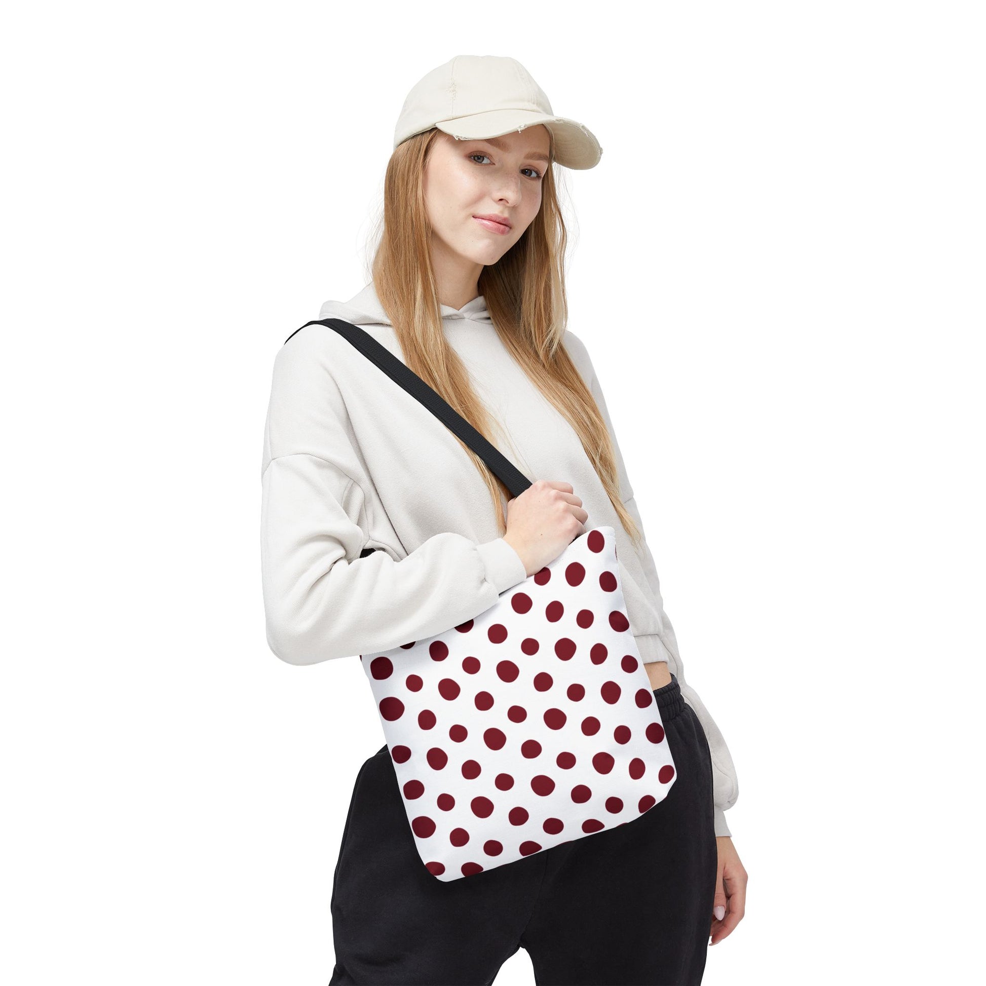 Burgundy Polka Dots Tote Bag held by a woman, showcasing its stylish design. Ideal for everyday use with durable polyester fabric and comfortable handles, perfect for adding a joyful touch to your day.