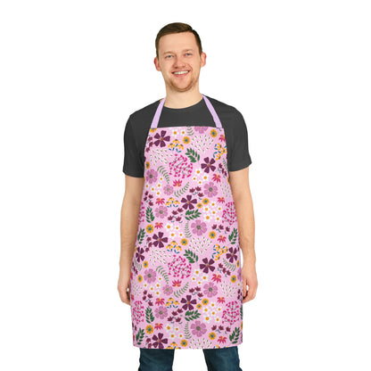 Floral Apron: A person models a knee-length apron with a vibrant pink floral pattern, showcasing FireBrook Essentials' stylish, stain-free design made from soft polyester canvas, ideal for joyful cooking and crafting.