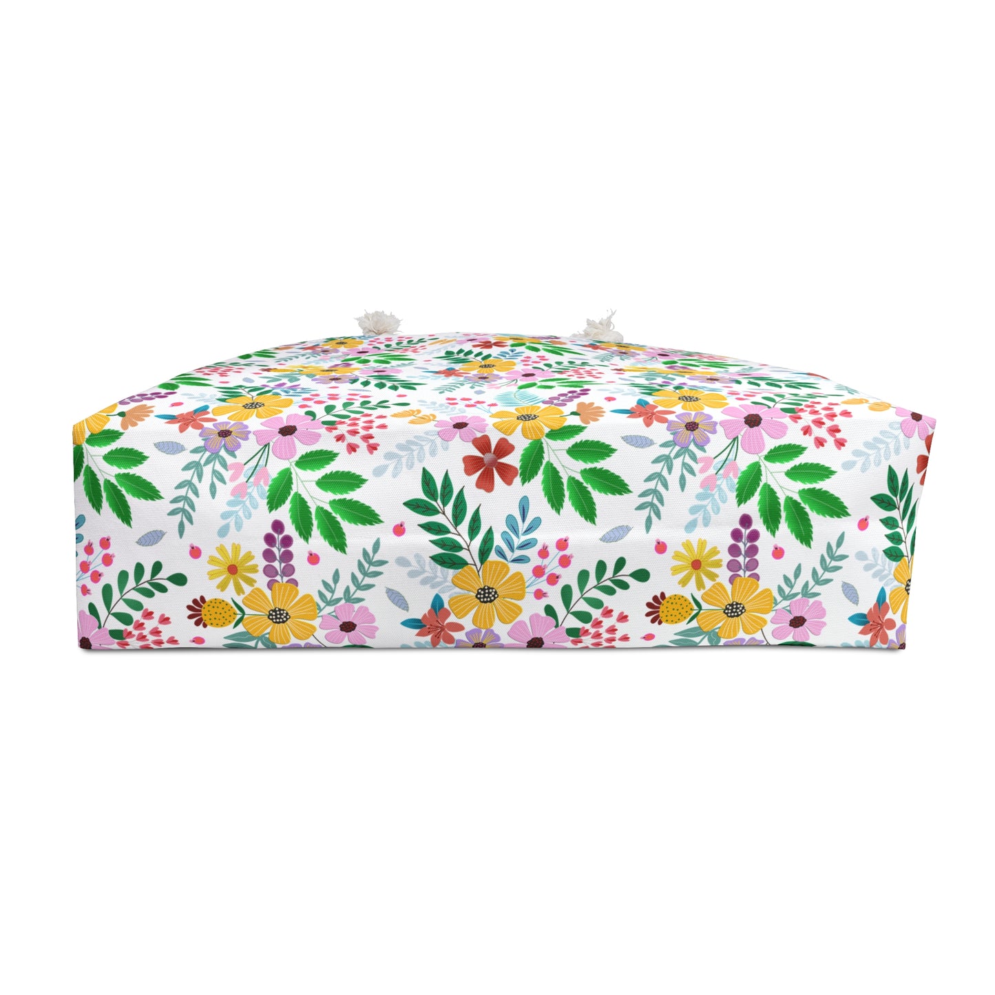 Weekender Bag: A low, box-shaped floor pouf with a vibrant floral and leaf pattern, featuring tassel-style knots on top corners, embodies FireBrook Essentials' commitment to stylish, joyful designs.