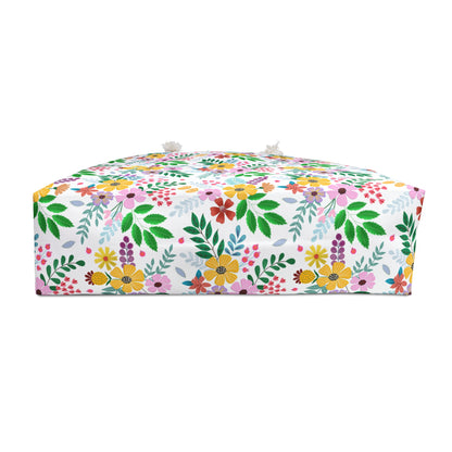 Weekender Bag: A low, box-shaped floor pouf with a vibrant floral and leaf pattern, featuring tassel-style knots on top corners, embodies FireBrook Essentials' commitment to stylish, joyful designs.