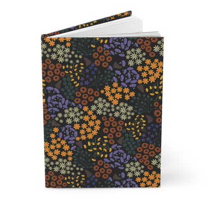 HARDCOVER JOURNAL, MATTE, RULED, 5X7, SEWN BIND, CLEAN-TEAR PAGES - AUTUMN NIGHT stands upright, showcasing its floral patterned cover and slightly open to reveal blank pages, embodying FireBrook Essentials' uplifting design ethos.