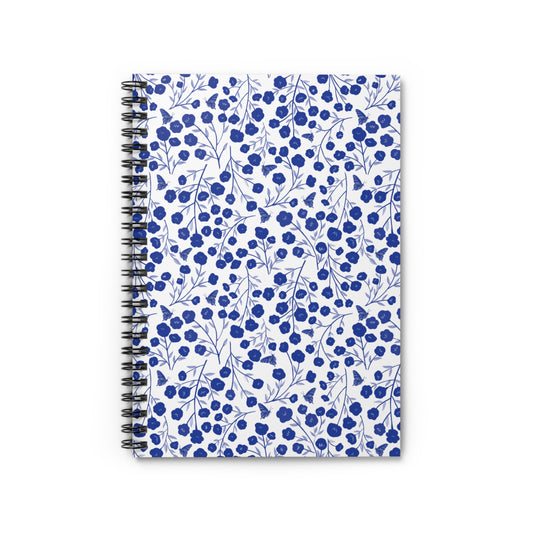 Floral Spiral Notebook featuring a white cover with a pattern of blue blossoms and butterflies, combining style and functionality for creative expression. Perfect for jotting notes or sketching ideas.