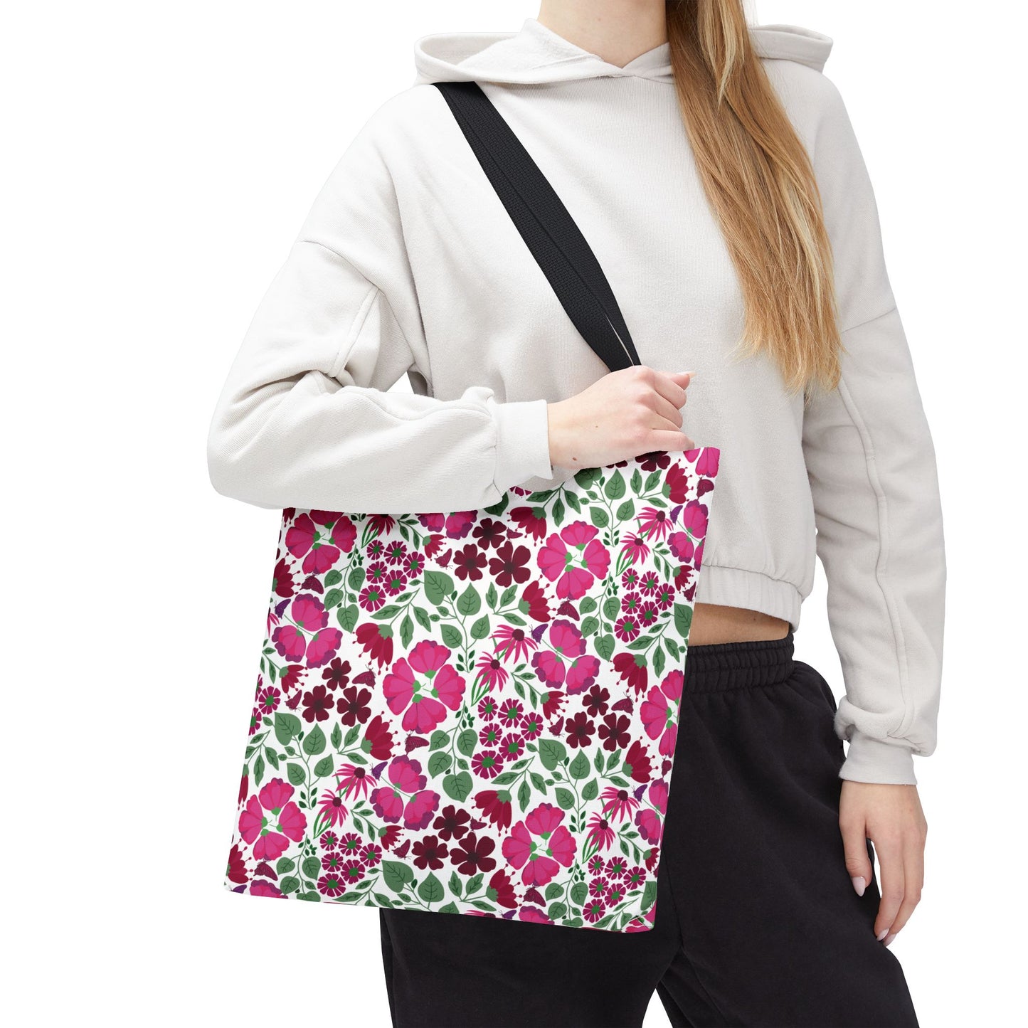The Pink Lady Tote Bag showcases a vibrant floral pattern with pink, magenta, and burgundy blooms, perfect for adding a pop of color to everyday outfits.