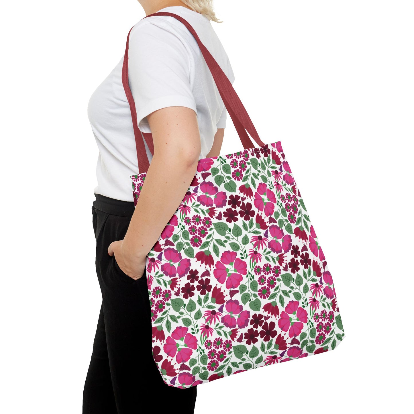 Person carrying a Pink Lady Tote Bag, featuring vibrant pink and berry floral prints with burgundy straps, ideal for adding a cheerful touch to everyday outfits, from FireBrook Designs.