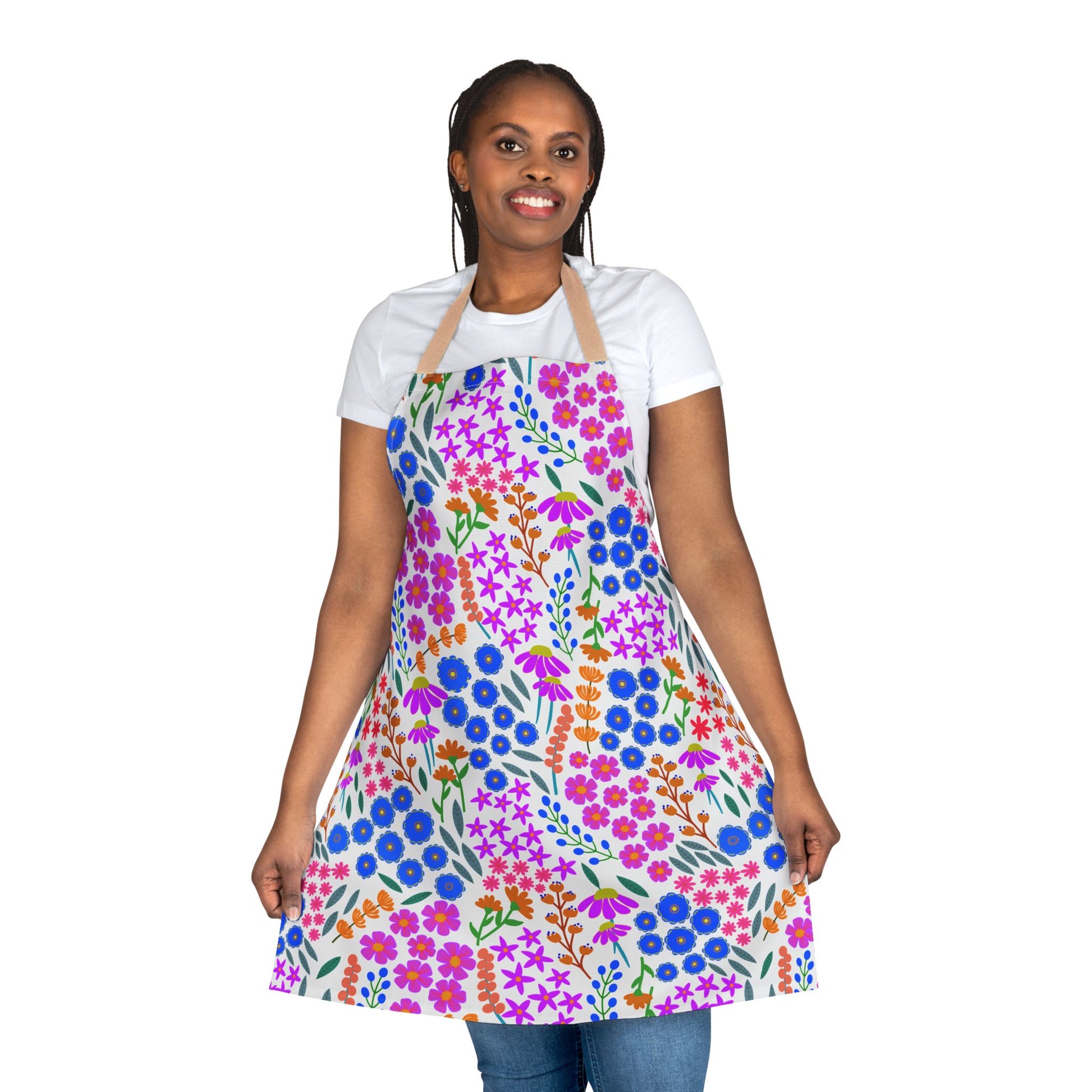 Person wearing a Floral Apron with vibrant floral patterns, showcasing its design by holding the sides. Made of soft, stain-free polyester canvas, ideal for enhancing joyful, stylish occasions.