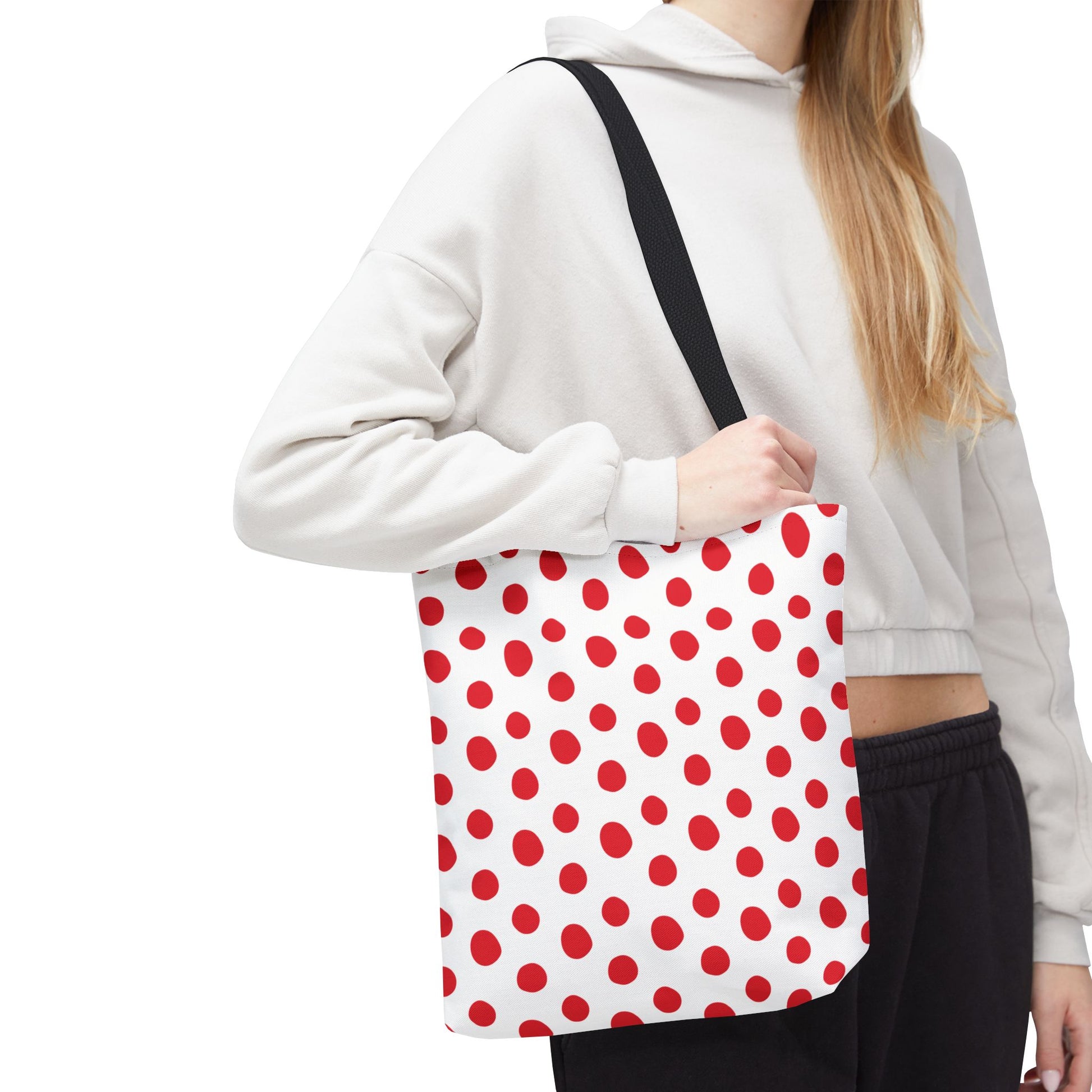 Red Polka Dots Tote Bag, held by a woman, showcases a playful red polka dot pattern, ideal for daily use. Features durable polyester, reinforced handles, and boxed corners for extra space.