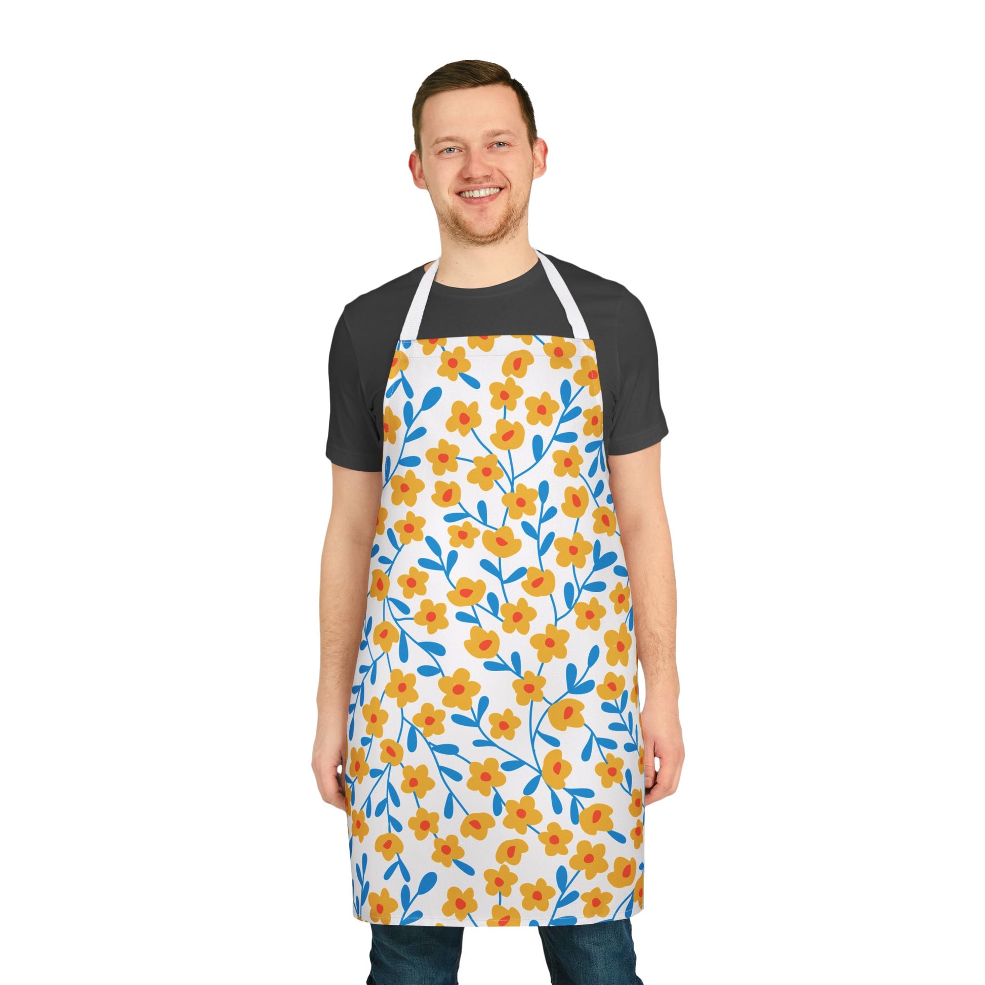 Floral Apron featuring a vibrant pattern of yellow-orange flowers with red centers and blue stems, worn by a smiling man. Perfect for various activities, offering comfort and style from FireBrook Essentials.