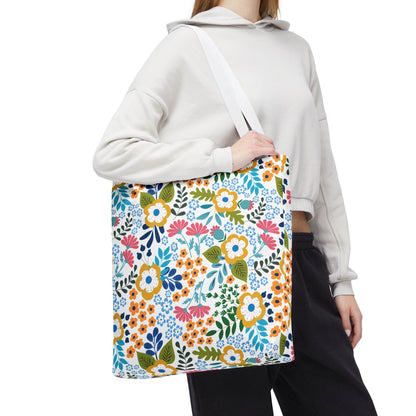 Floral Tote Bag with vibrant mustard-yellow, coral-pink, and sky-blue blossoms, carried over the shoulder by a person in a light hoodie, embodies FireBrook Designs' uplifting and joyful style.
