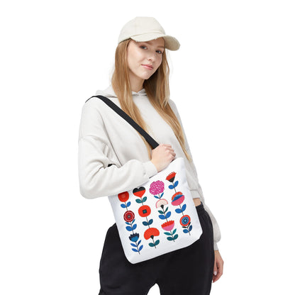 Woman wearing a hat holds a Floral Pattern Tote Bag with a vibrant flower design, embodying FireBrook Essentials' blend of style and functionality.