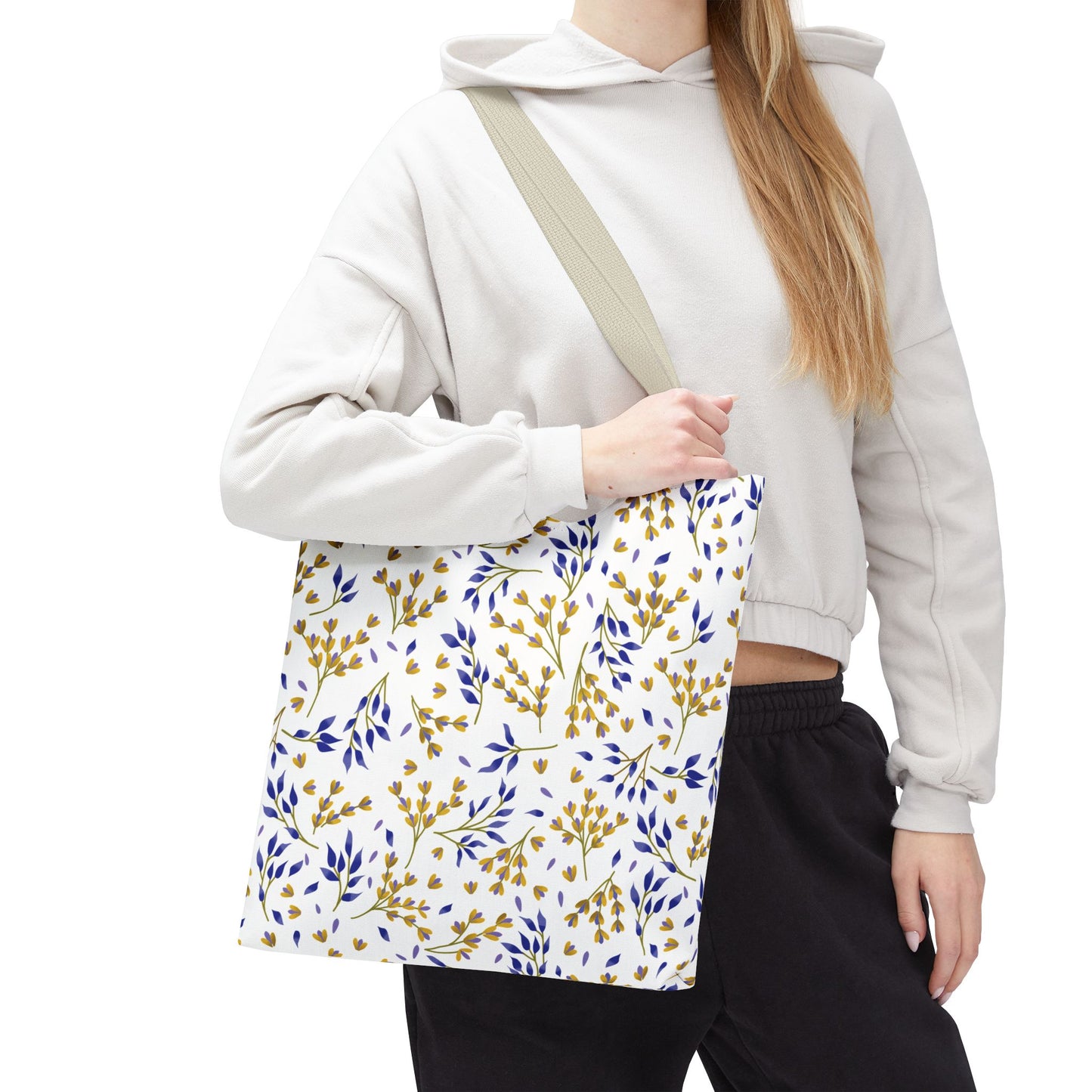 Floral Tote Bag with yellow and blue botanical pattern, carried by a person in casual attire. This stylish accessory, featuring a tan strap, embodies FireBrook Designs' commitment to joyful, uplifting design.