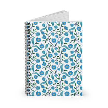 Floral Spiral Notebook featuring a vibrant pattern of blue flowers with yellow centers and green leaves, standing upright. Its black coil binding and white pages enhance its stylish, functional design for creative expression.