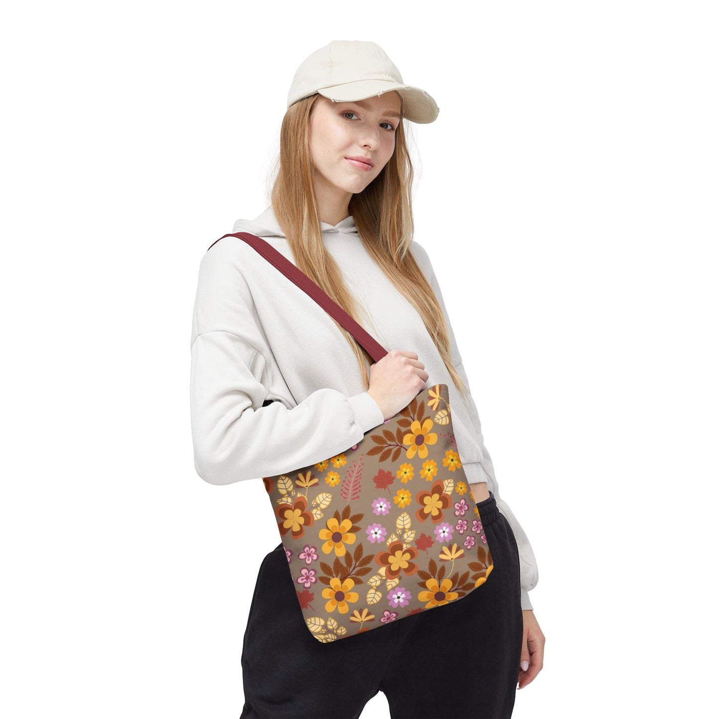 Young woman models the Harvest Brown Bloom Tote Bag, featuring a wide burgundy strap and a retro floral print in warm autumn tones, perfect for brightening summer outings or market trips.