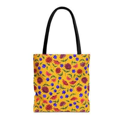 Golden Wildflower Tote Bag: A vibrant canvas tote with black handles, featuring a lively pattern of red daisylike flowers, blue blossoms, and green leaves on a yellow background, embodies joyful, practical style.
