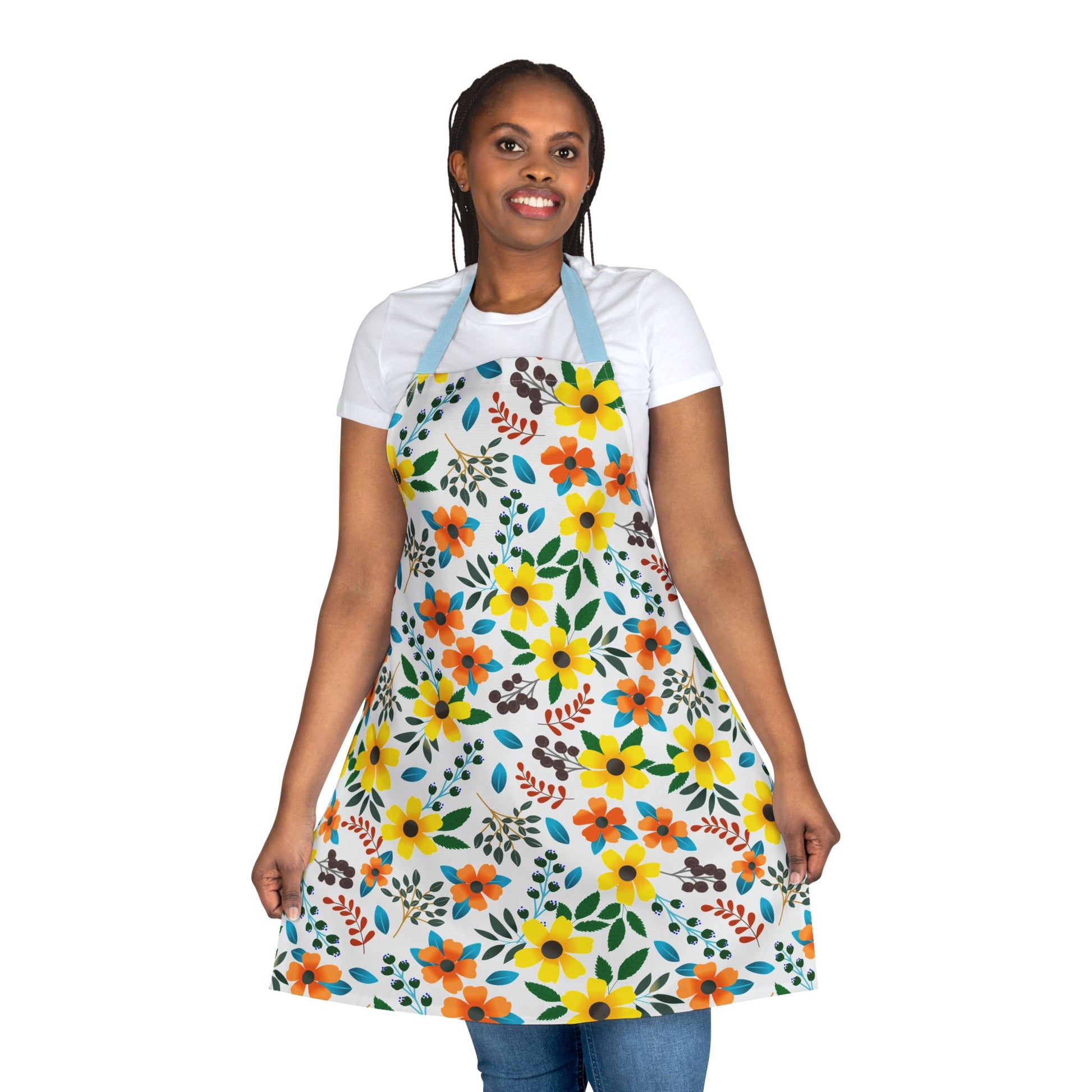 A person wears the Floral Apron from FireBrook Designs, featuring vibrant yellow and orange flowers with green leaves, offering a cheerful, stain-free protection ideal for cooking and crafting.