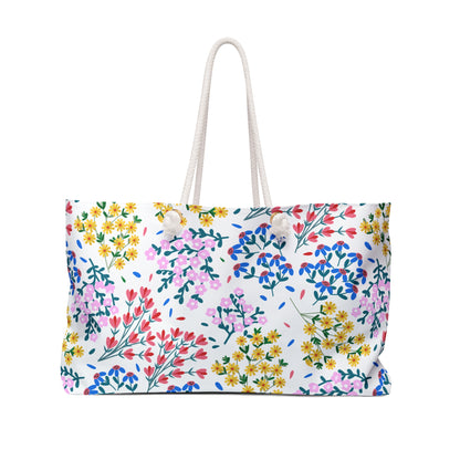 Weekender Bag with vibrant floral pattern and thick white rope handles, ideal for stylish travel. Features a spacious design, durable spun polyester material, and luxurious cream interior lining.