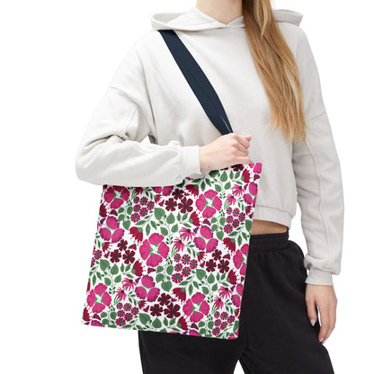 A person holds the Pink Lady Tote Bag, showcasing its vibrant floral pattern of pink and magenta flowers with green leaves, perfectly complementing any outfit while embodying FireBrook Designs' uplifting and stylish essence.