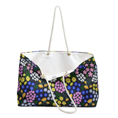 Weekender Bag with vibrant floral print on a black background, featuring rope handles and a white interior. Ideal for stylish weekend getaways, reflecting FireBrook Designs’ commitment to joyful, uplifting products.