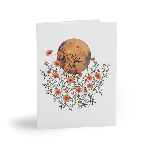 Moon Greeting Cards — Pack of 8/16/24 features a vibrant full moon illustration with orange wildflowers, folded and ready to inspire gratitude or celebration, complete with matching white envelopes.