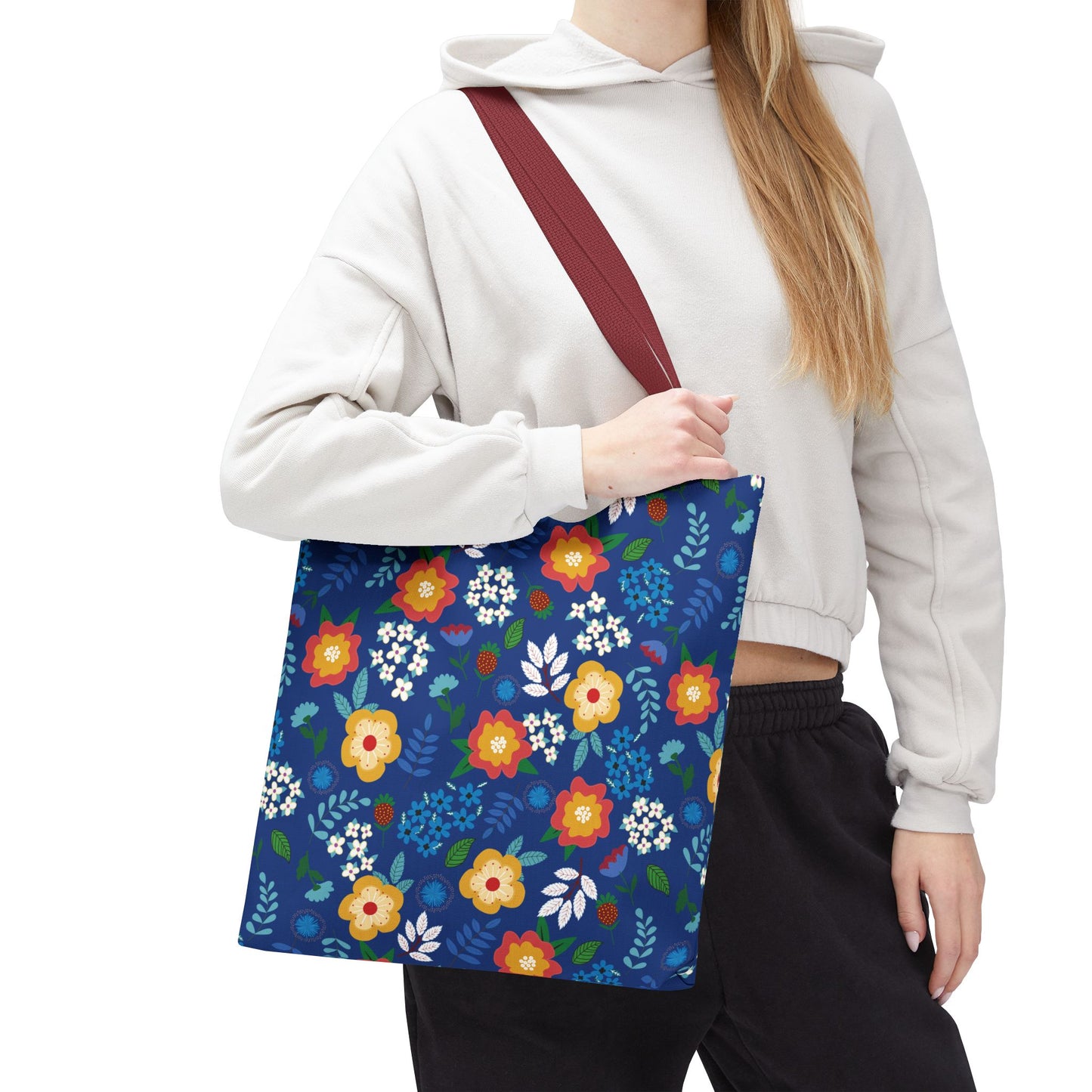 Floral Tote Bag features a navy background with vibrant floral patterns and a burgundy-red strap, ideal for summer outings. Its durable polyester body and reinforced stitching ensure both style and functionality.