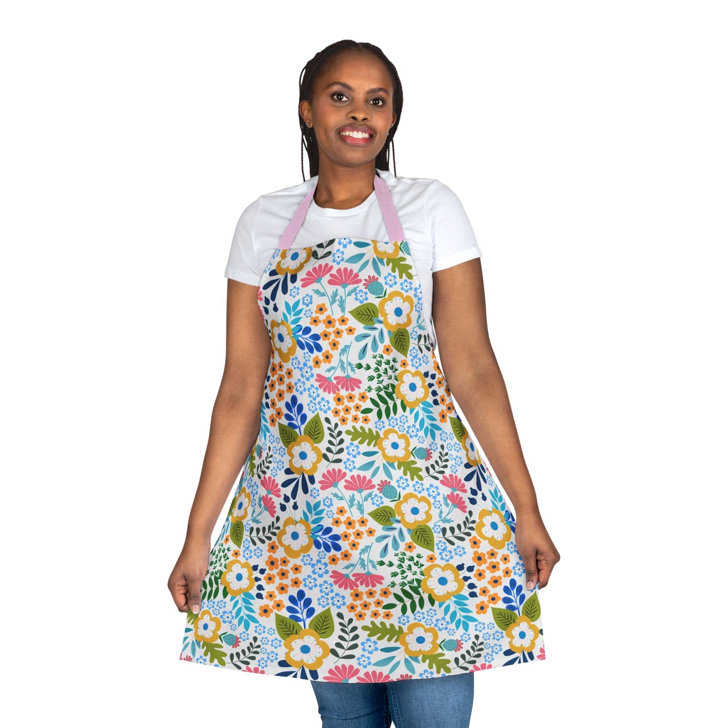 Smiling woman wears a Floral Apron with vibrant flower patterns, layered over casual attire. Crafted from stain-free polyester canvas, it’s ideal for cooking or crafting, embodying FireBrook Designs' joyful, practical style.