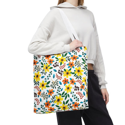 A person models the Sunny Meadow Mix Tote Bag, featuring vibrant yellow and orange daisies on a white background, perfect for summer outings, embodying FireBrook Designs' cheerful and uplifting aesthetic.