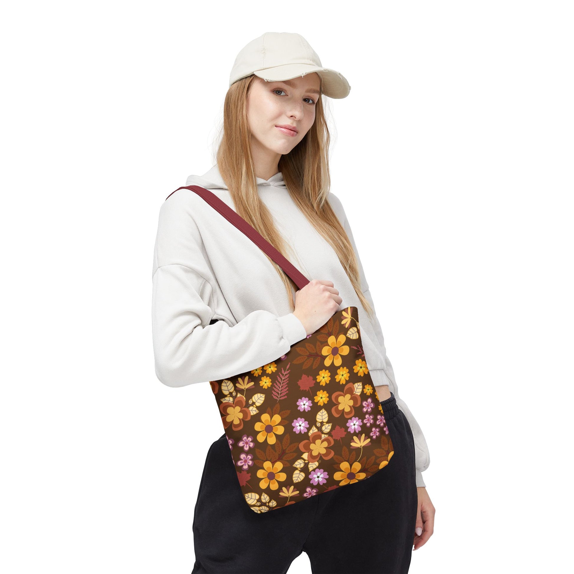 Young woman models the Floral Tote Bag, featuring a dark brown backdrop with vibrant autumnal flowers. Ideal for cheerful summer outings, it's durable and stylish, embodying FireBrook Essentials' commitment to joyful, uplifting designs.