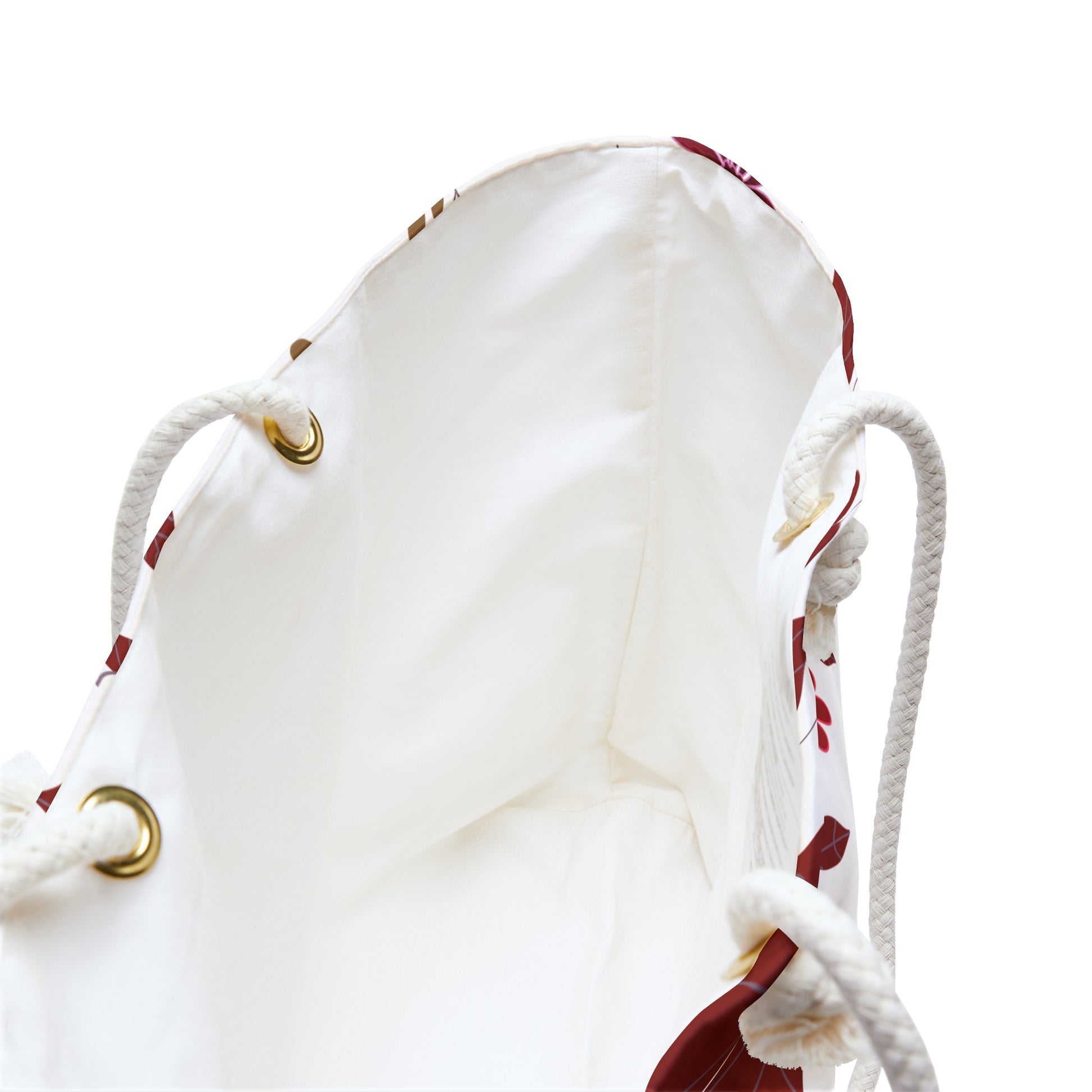 The Weekender Bag features a spacious cream interior with rope handles through brass grommets, ideal for stylish travel. The red-patterned exterior hints at FireBrook Essentials' uplifting design ethos.