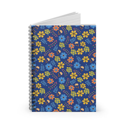 Floral Spiral Notebook with vibrant orange, yellow, and blue floral pattern on navy cover, standing upright. White, lined pages visible at top, embodying FireBrook Designs' cheerful and uplifting style.