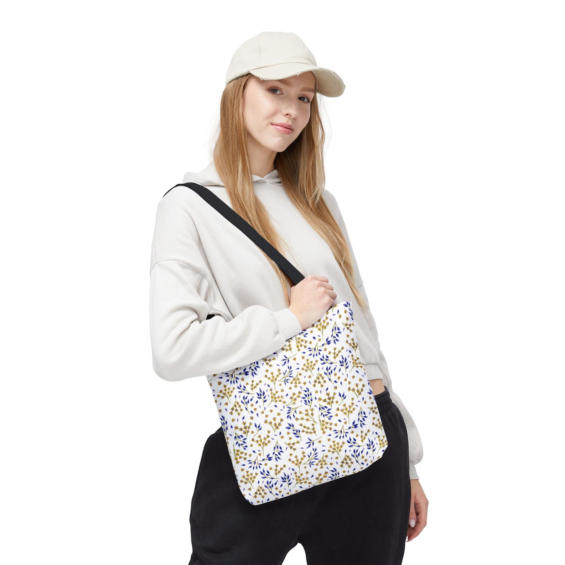 Wild Herb Garden Tote Bag with blue and gold floral pattern, showcased by a young woman. Perfect for summer outings, it features durable polyester, reinforced handles, and boxed corners for extra space.