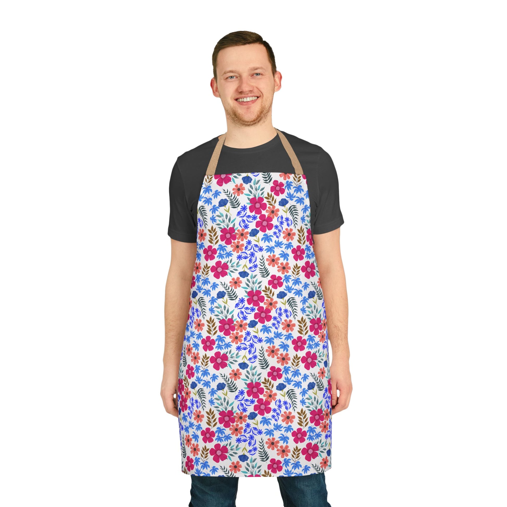 Man wearing the Apron Floral Design, featuring vibrant pink, orange, and blue flowers with green leaves. This stain-free, polyester canvas apron by FireBrook Designs offers comfort and style, perfect for cooking or hosting.