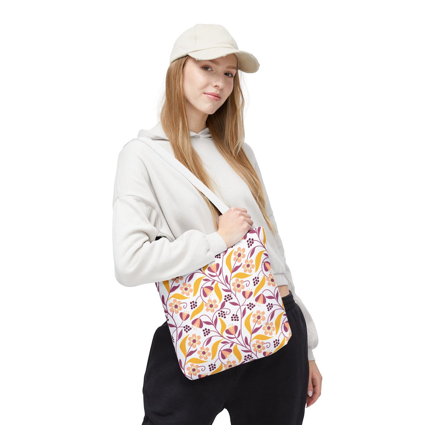 A casually dressed person carries the Floral Tote Bag, showcasing its vibrant yellow, orange, pink, and purple floral pattern. Ideal for summer outings, this durable polyester bag offers style and practicality.