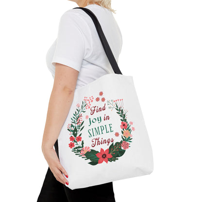 Find Joy in Simple Things Tote Bag with a watercolor floral design, held by a woman in a white shirt, embodying style and practicality.