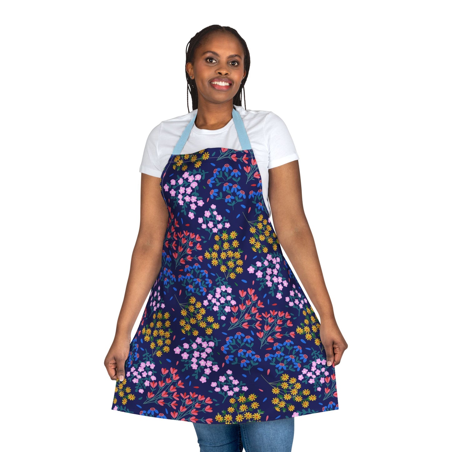Person wearing a Floral Apron with a vibrant multicolored floral pattern, smiling and holding its edges to display design. Made of soft, stain-free polyester, perfect for joyful cooking or crafting.