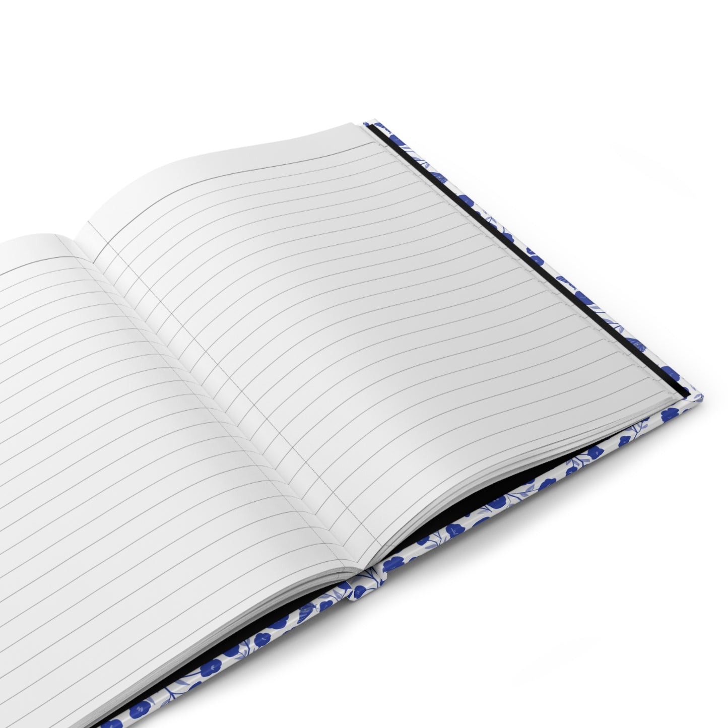 HARDCOVER JOURNAL, MATTE, RULED, 5X7, SEWN BIND, CLEAN-TEAR PAGES – INDIGO PETALS lies open, showcasing blank, lined pages and a blue floral-patterned cover, embodying FireBrook Essentials' uplifting design ethos.