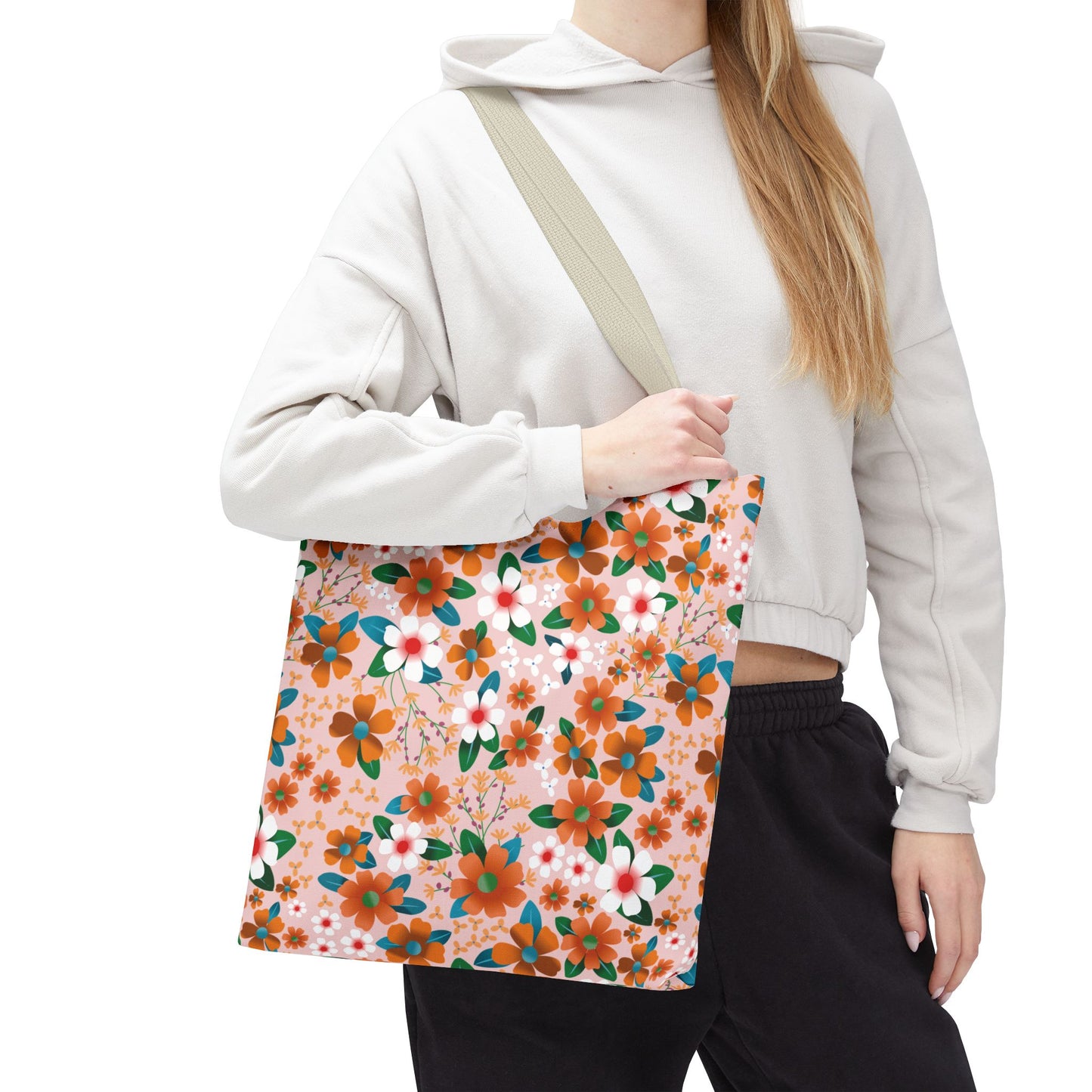 Peach Poppy Grove Tote Bag with vibrant floral design on a peach background, held over the shoulder. Ideal for summer outings, featuring reinforced handles and boxed corners for extra space.