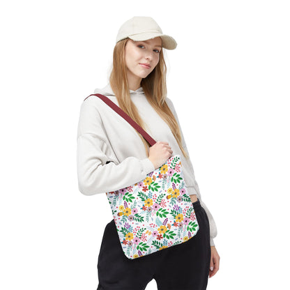 A young woman models the Spring Floral Patch Tote Bag, showcasing its vibrant floral-and-leaf pattern. The durable tote is ideal for sunny outings, embodying FireBrook Essentials' joyful and stylish design ethos.