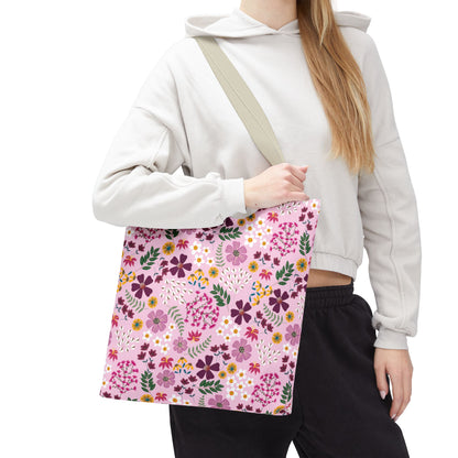 The Rose Garden Blush Tote Bag features a colorful floral pattern with daisies and stylized blooms, complemented by a neutral shoulder strap, embodying FireBrook Designs' blend of style and durability.