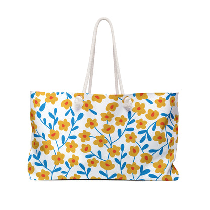 Weekender Bag featuring a stylized floral pattern with mustard-yellow flowers, reddish centers, and blue stems on a white background. Equipped with sturdy white rope handles, this spacious bag is perfect for stylish getaways.