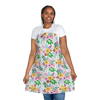 Woman wearing a Floral Apron with bright, multicolored floral-and-foliage pattern, showcasing its full coverage and comfortable polyester canvas design. Ideal for kitchen activities, reflecting FireBrook Essentials' uplifting style.