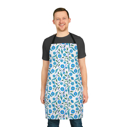 Man wearing Apron Floral Design with blue flowers and green leaves over dark-gray T-shirt and jeans, embodying FireBrook Essentials' blend of comfort and style for joyful daily activities.