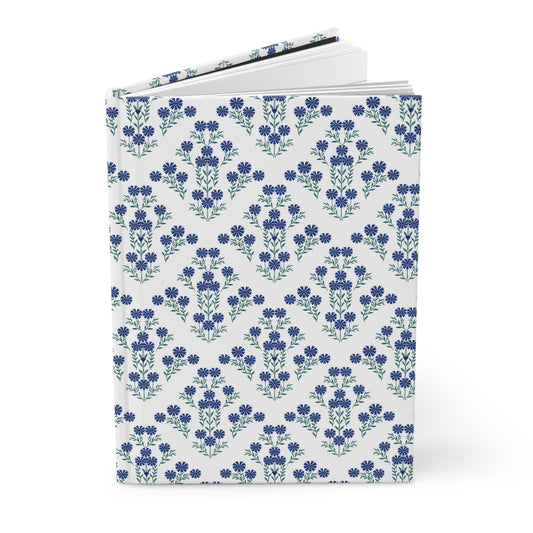 HARDCOVER JOURNAL, MATTE, RULED, 5X7, SEWN BIND, CLEAN-TEAR PAGES – INDIGO DAISY features a white cover adorned with a seamless pattern of blue flowers, showcasing its elegant, durable design for uplifting daily use.