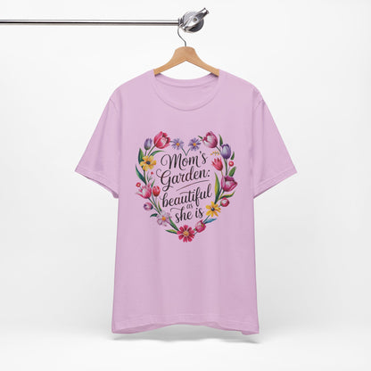 Mom's Garden is as Beautiful as She Is Mother's Day Comfort Colors Unisex T-Shirt, featuring a heart-shaped floral design with black text, hanging on a wooden swinger.