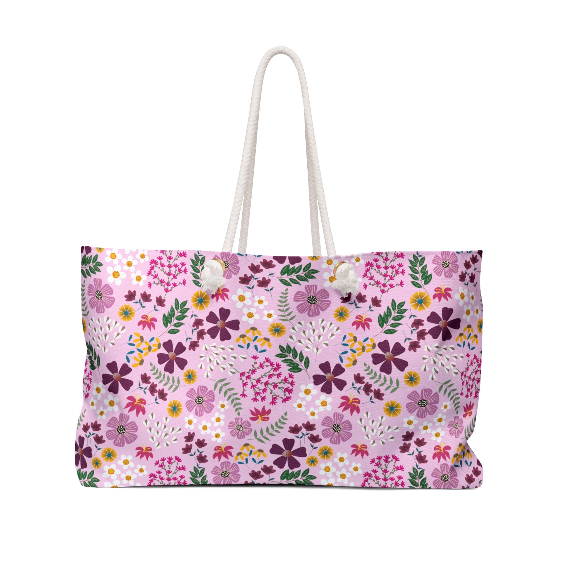 Weekender Bag with a floral pattern on pale pink canvas, featuring thick white rope handles. Ideal for stylish getaways, this spacious tote reflects FireBrook Essentials' commitment to joyful, uplifting design.