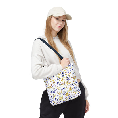 Floral Tote Bag slung over a casually dressed woman's shoulder, featuring a scattered leaf pattern in gold and blue tones, embodies stylish functionality for joyful summer outings, aligning with FireBrook Designs’ uplifting ethos.