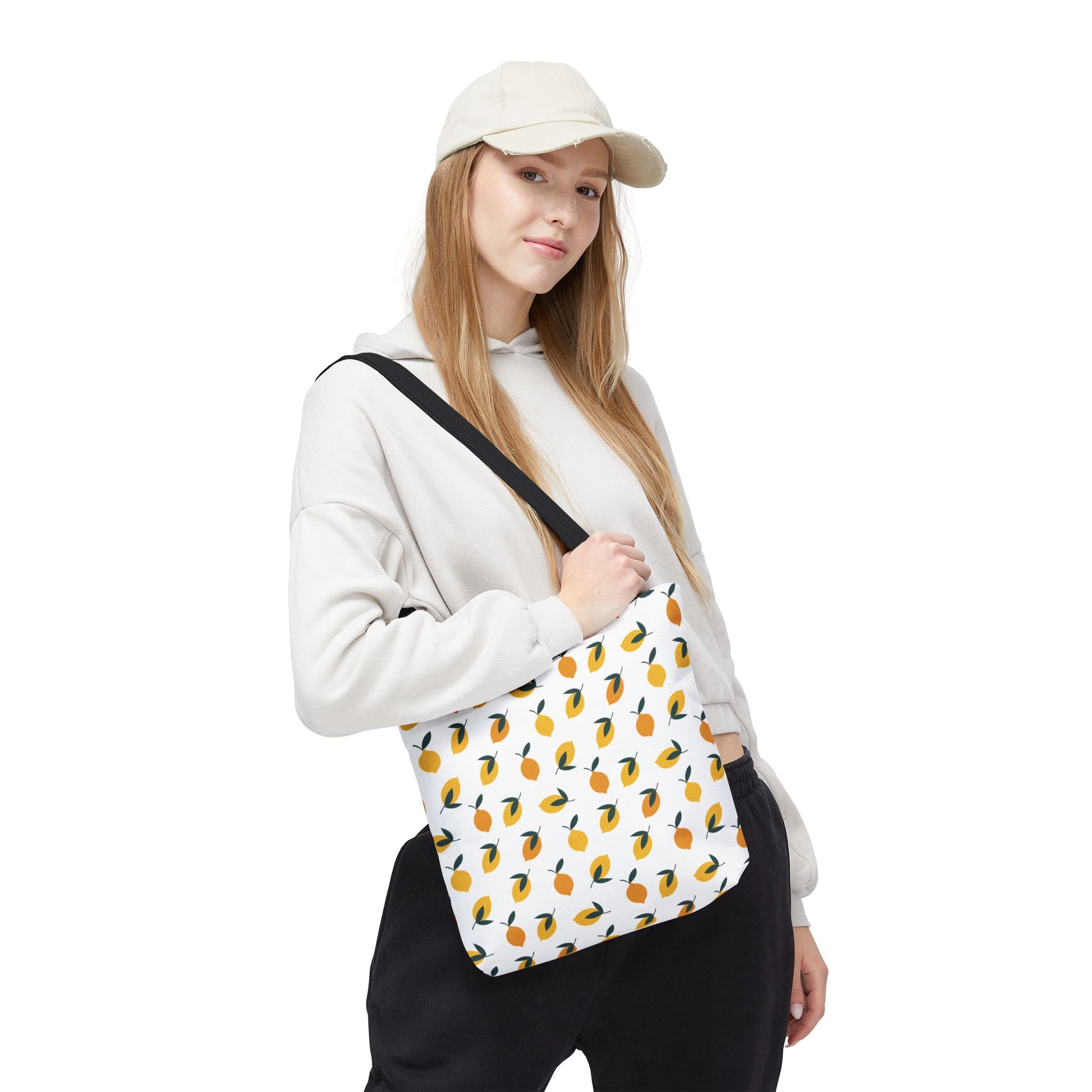 Lemon Tote Bag - Fresh and Fun Citrus Pattern worn by a young woman, showcases vibrant orange and yellow fruit illustrations with green leaves, offering a cheerful, summery touch perfect for joyful outings.